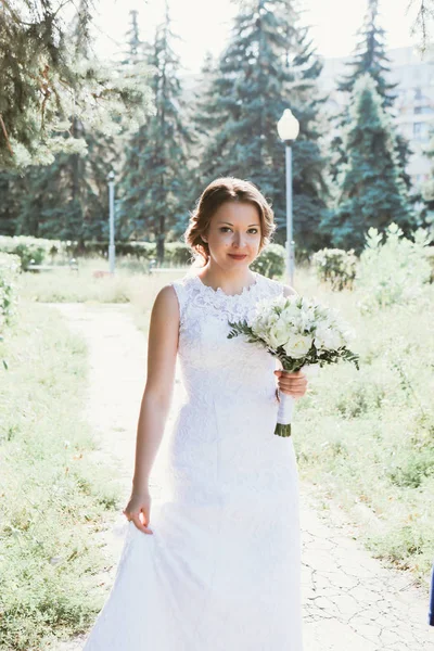Porträt einer jungen Braut im Hintergrund des Parks — Stockfoto