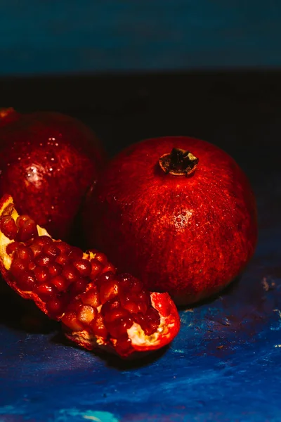 Red sliced pomegranate on a blue abstraction background — Stock Photo, Image