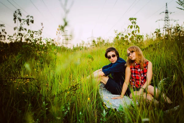 Chico y la chica sentada en la hierba — Foto de Stock
