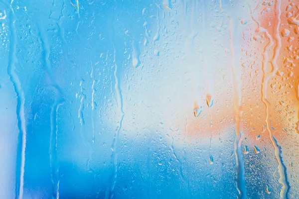 Gotas de chuva em um fundo multicolorido borrado — Fotografia de Stock