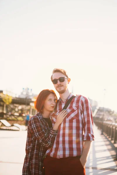 Hombre y mujer en la camisa a cuadros abrazándose en el fondo de la ciudad — Foto de Stock