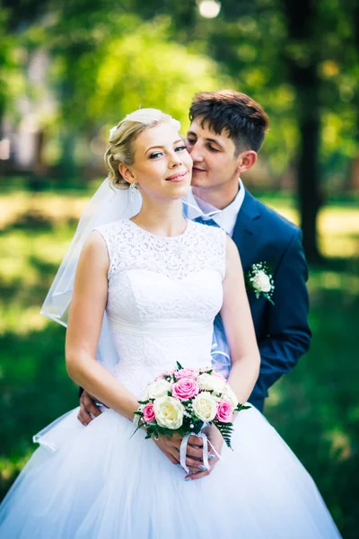 Portrait the bride and groom on the background of the park alley — Stock Photo, Image