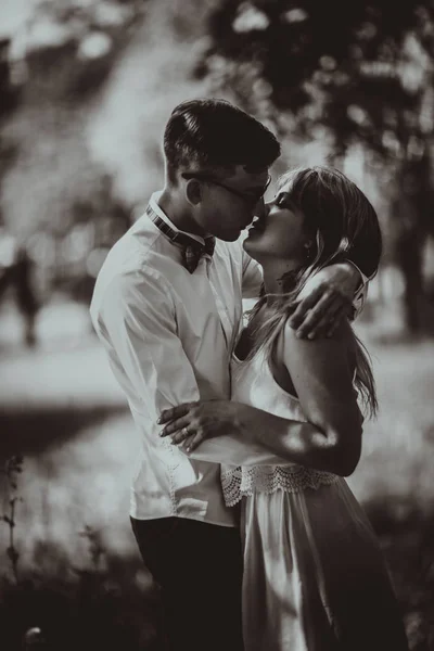 Fekete-fehér fénykép fiatal szép pár a természetes elmosódott háttér — Stock Fotó