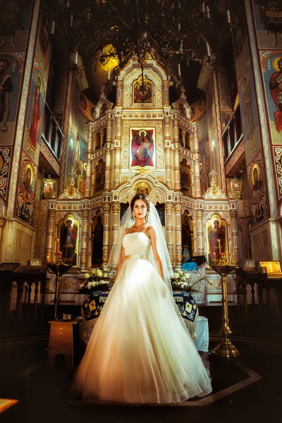 Elegante sposa elegante su sfondo la vecchia chiesa — Foto Stock