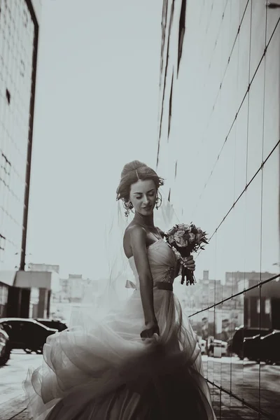 Bride and bouquet on backround mirror buildings. — Stock Photo, Image