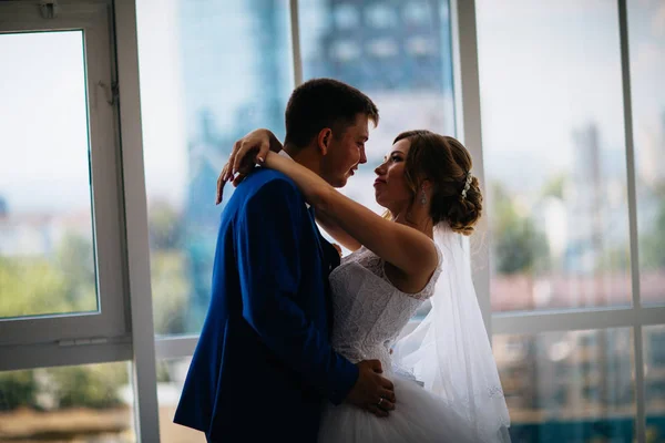 Bride and groom on background clear windows — Stock Photo, Image