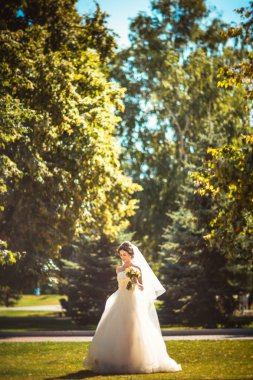 Parkta yürüyen güzel esmer gelin.