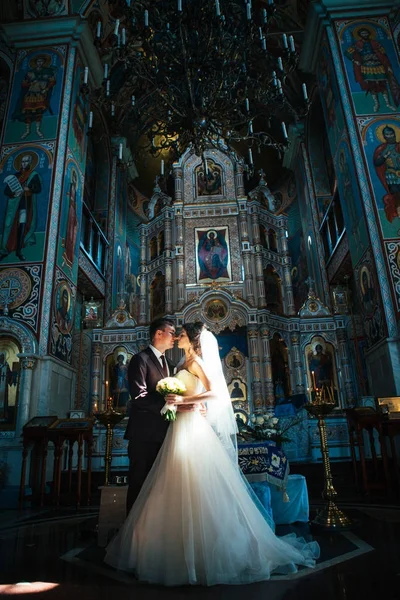 若いカップルの新郎と新婦教会の背景に — ストック写真