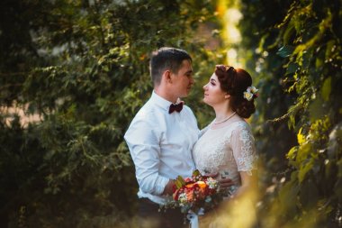 Gelin ve damat ağaçların yapraklarında