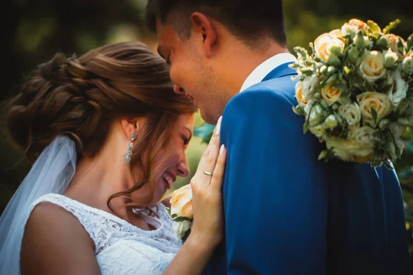 Coppia sposo e sposa abbracciare e baciare su sfondo parco naturale — Foto Stock