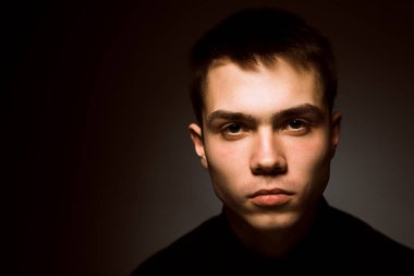 Karanlık stüdyo geçmişi olan genç bir adam.