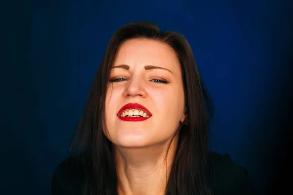 Emotionell flicka ler på en mörk bakgrund — Stockfoto