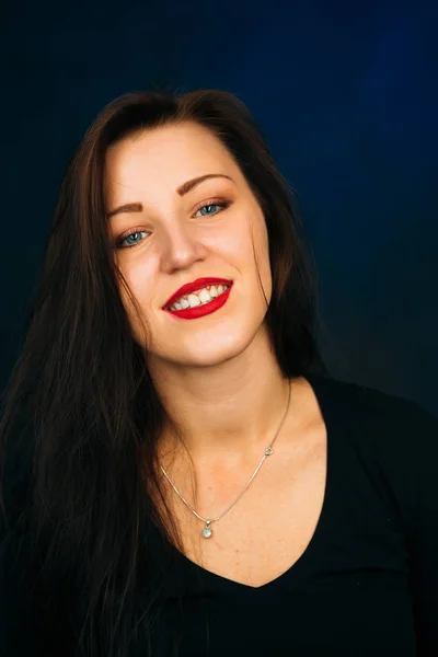 Emotional girl smiling on a dark background — Stock Photo, Image