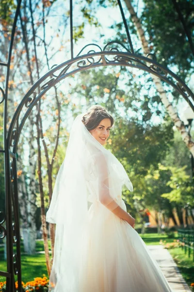 Jovem noiva bonita de pé em um gazebo parque . — Fotografia de Stock