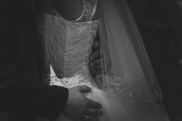 Paar bruidegom en bruid knuffelen op donkere achtergrond — Stockfoto