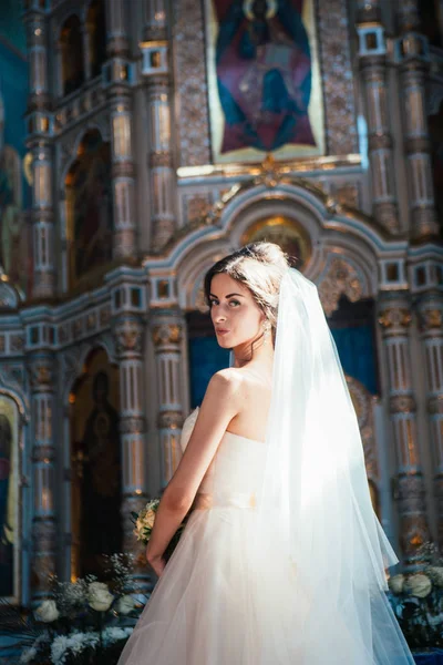 Elegante novia elegante en el fondo de la antigua iglesia — Foto de Stock