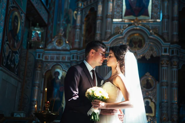 Joven pareja novio y novia en la iglesia fondo — Foto de Stock