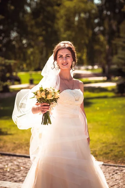 Den vackra brunett bruden på en promenad i parken — Stockfoto