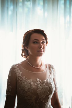 Pencerenin yanında genç ve güzel bir gelinin portresi