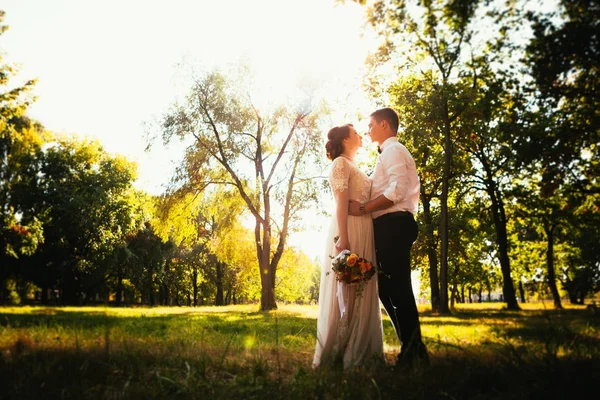 Жених и невеста на фоне парковых деревьев — стоковое фото