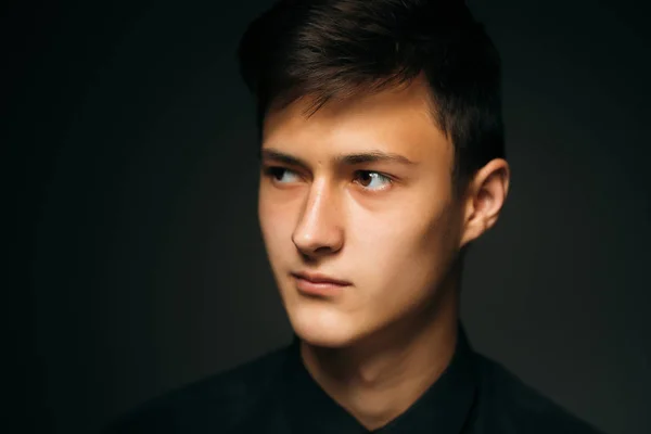 Karanlık bir stüdyoda genç bir adam portresi — Stok fotoğraf