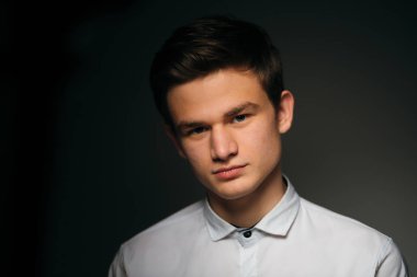 Genç, esmer, beyaz gömlekli adam.