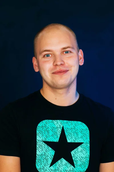 Jovem cara careca em um colete em um fundo escuro — Fotografia de Stock