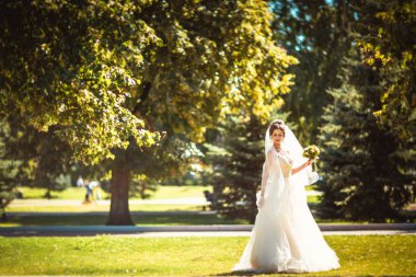 Parkta yürüyen güzel esmer gelin.