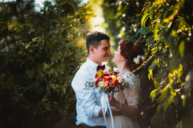 Gelin ve damat ağaçların yapraklarında