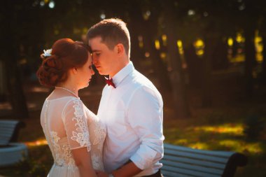 Damat ve gelin parkın ağaçlarına karşı