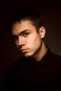 Karanlık stüdyo geçmişi olan genç bir adam.