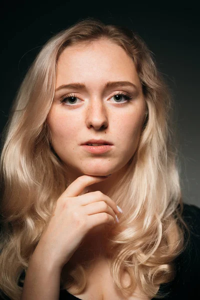 Jong meisje blond op een donkere achtergrond — Stockfoto