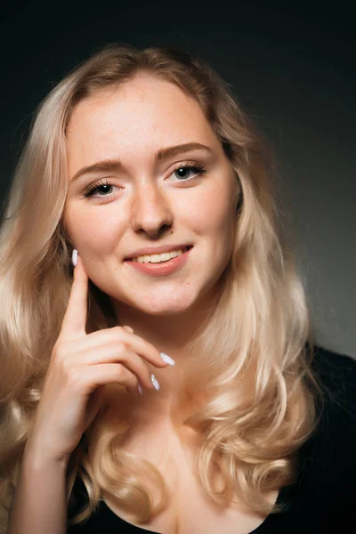 Ung flicka blond på en mörk bakgrund — Stockfoto