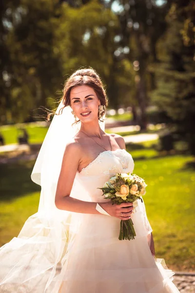 Красивая брюнетка невеста на прогулке в парке — стоковое фото