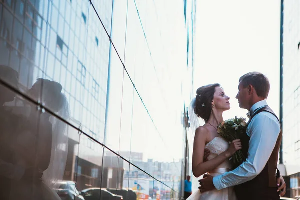 Arkadaki ayna binalarında düğün çifti — Stok fotoğraf