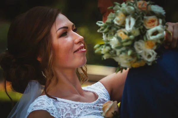 Casal noivo e noiva abraçando e beijando no parque da natureza fundo — Fotografia de Stock