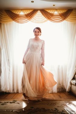 Pencerenin yanında genç ve güzel bir gelin var.