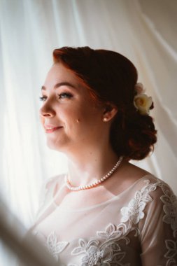 Pencerenin yanında genç ve güzel bir gelinin portresi