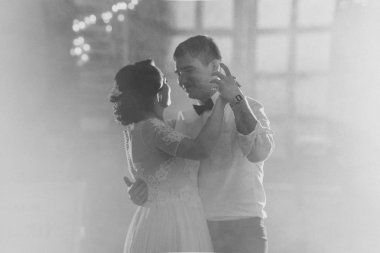 Siyah ve beyaz fotoğraf gelin ve damat ilk dansı bulanık arka planda dans