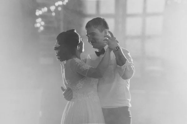 Чорно-біле фото нареченого і нареченого танцюють перший танець на розмитому фоні — стокове фото