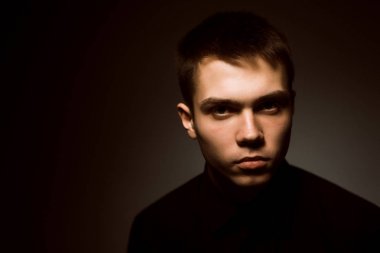 Karanlık stüdyo geçmişi olan genç bir adam.