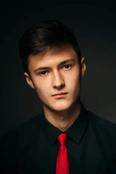Portrait young guy on a dark studio — Stock Photo, Image