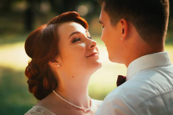 The bride and groom in the background of park trees — Stock Photo, Image