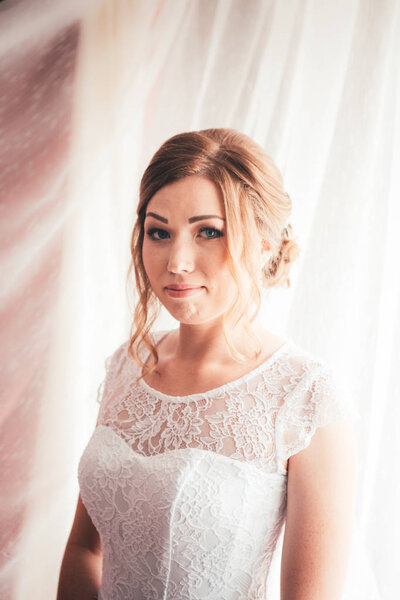 Portrait of a young bride on a light background.