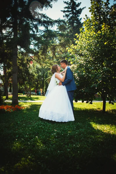 Pár ženich a nevěsta na pozadí parku v plném růstu — Stock fotografie