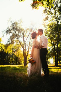 Gelin ve damat park ağaçlarının arkasında