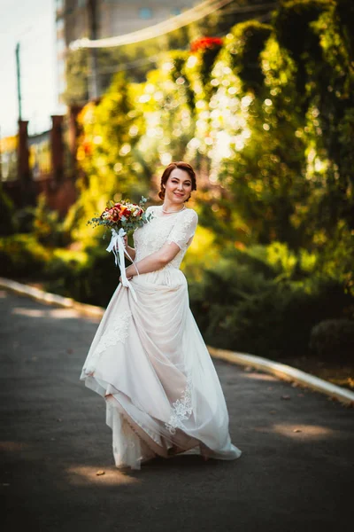 Mariée sur un fond d'arbres dans le parc . — Photo