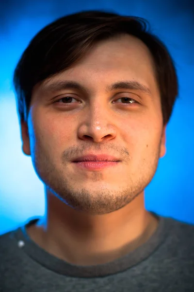 Porträt emotionaler junger Mann auf blauem Hintergrund — Stockfoto