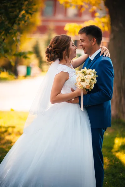 Noivo casal e noiva contra o fundo de folhas de laranja — Fotografia de Stock