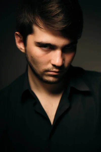 Young brunette guy on a dark background Royalty Free Stock Photos